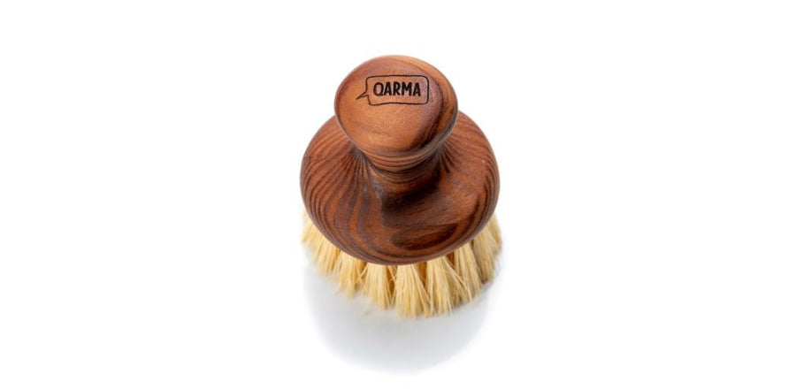 Vista desde arriba del cepillo de vajilla de madera con logo Qarma en el mango