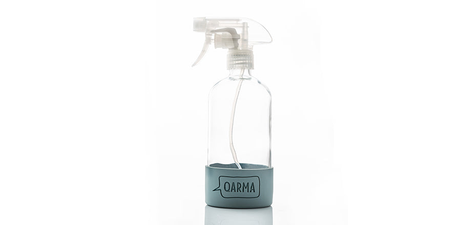 imagen de botella de vidrio con base de silicona logo Qarma y pistola spray transparente